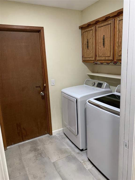 washroom featuring cabinets and washer and clothes dryer