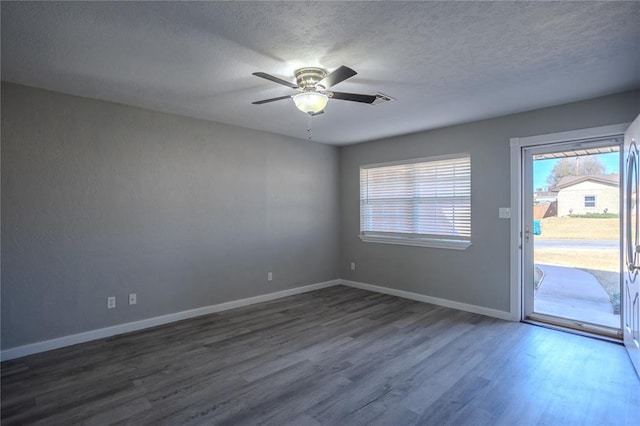 spare room featuring a textured ceiling, ceiling fan, and dark wood-type flooring