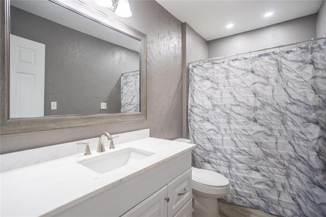 bathroom with a shower with curtain, vanity, and toilet