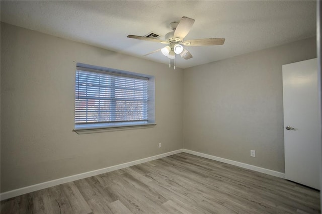 spare room with light wood-type flooring and ceiling fan