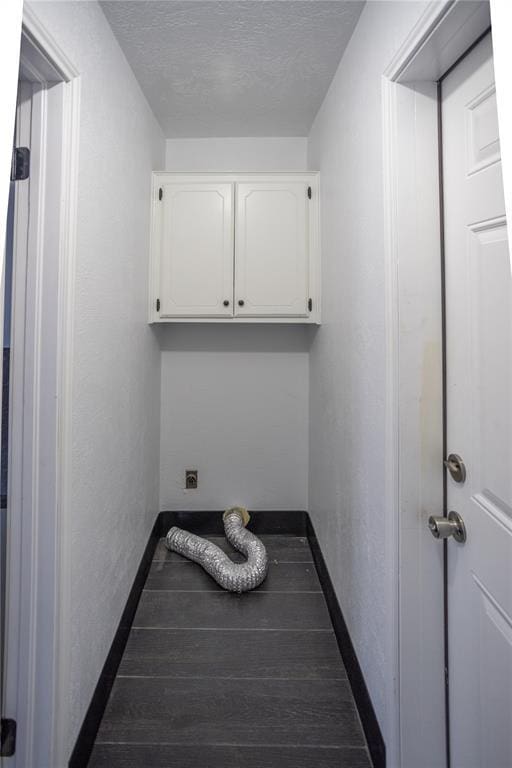 laundry room featuring cabinets and a textured ceiling