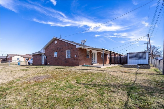 back of house with a storage unit, a yard, and a patio