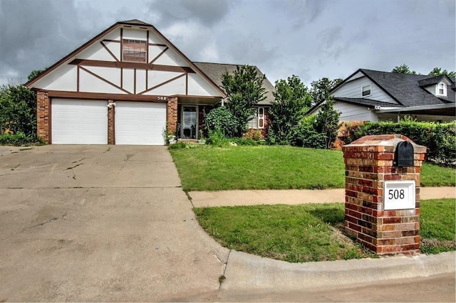 tudor-style house featuring a garage and a front yard