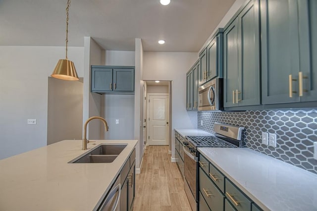 kitchen featuring appliances with stainless steel finishes, hanging light fixtures, light stone countertops, decorative backsplash, and sink