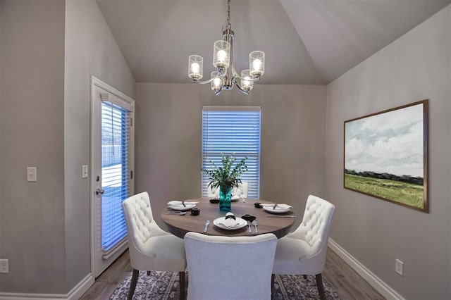 dining area featuring an inviting chandelier, lofted ceiling, and dark hardwood / wood-style flooring