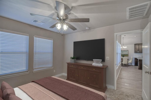 bedroom with ceiling fan with notable chandelier