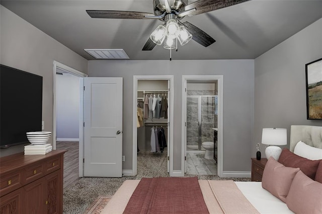 bedroom featuring a walk in closet, connected bathroom, ceiling fan, and a closet