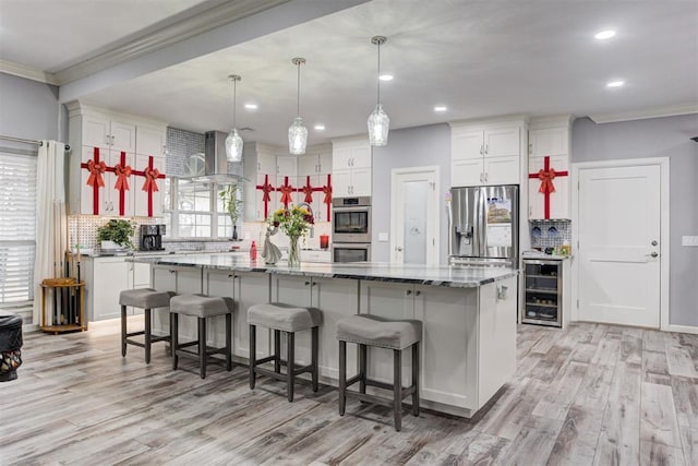 kitchen featuring wine cooler, decorative backsplash, a center island, and appliances with stainless steel finishes