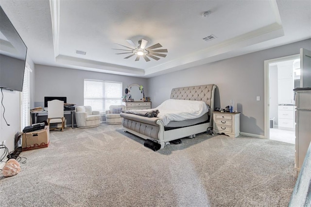 carpeted bedroom with a raised ceiling, ceiling fan, and ornamental molding