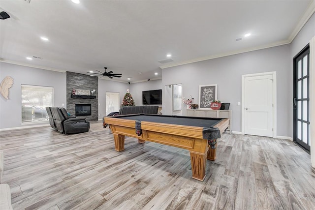 rec room with ceiling fan, a stone fireplace, light wood-type flooring, and billiards