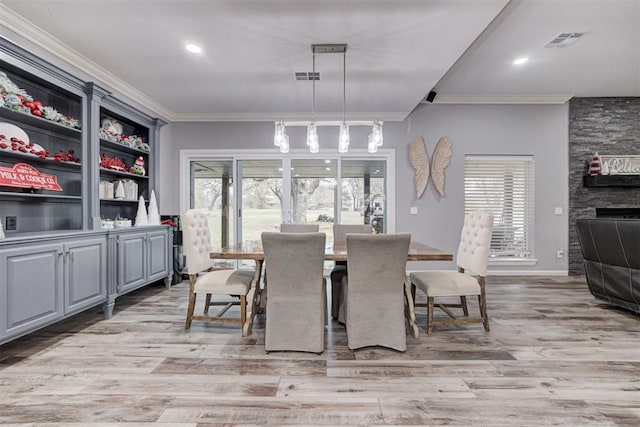 dining area with light hardwood / wood-style floors, plenty of natural light, and ornamental molding