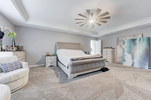 carpeted bedroom with a raised ceiling, ceiling fan, and crown molding