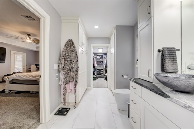 bathroom with vanity, toilet, and ceiling fan