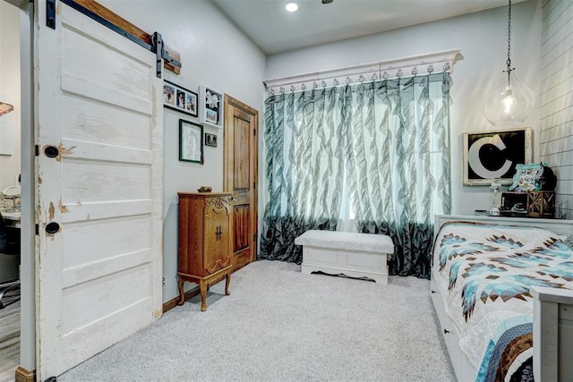 bedroom featuring a barn door and carpet floors