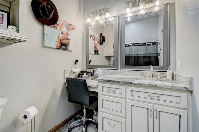 bathroom featuring vanity, toilet, and walk in shower