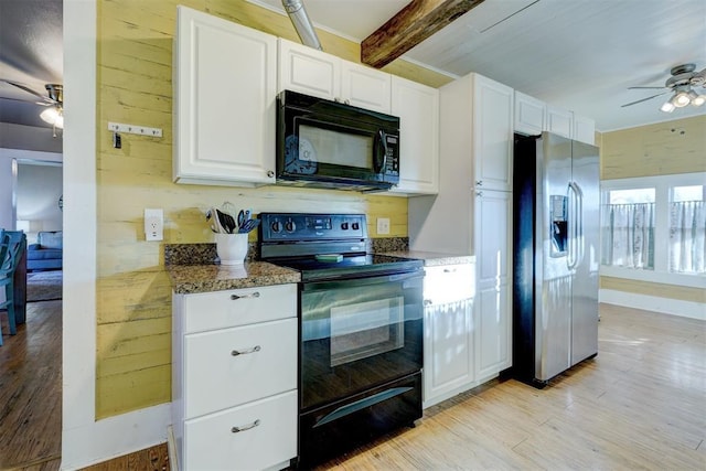 kitchen featuring light wood-type flooring, white cabinetry, dark stone counters, and black appliances