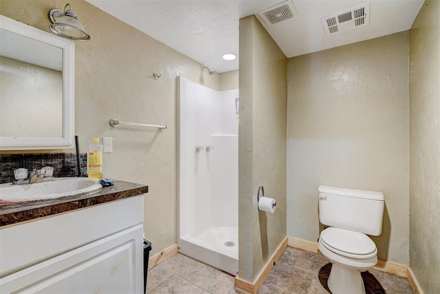 bathroom with tile patterned floors, vanity, toilet, and walk in shower