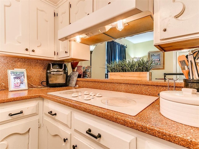 kitchen featuring white cabinets and white stovetop