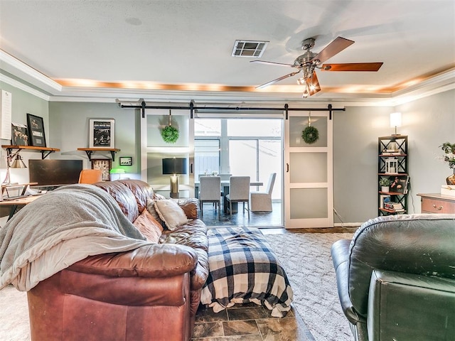 living room featuring ceiling fan, crown molding, and a barn door