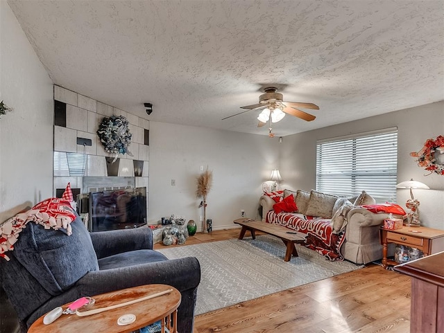 living room featuring ceiling fan, a textured ceiling, and hardwood / wood-style flooring