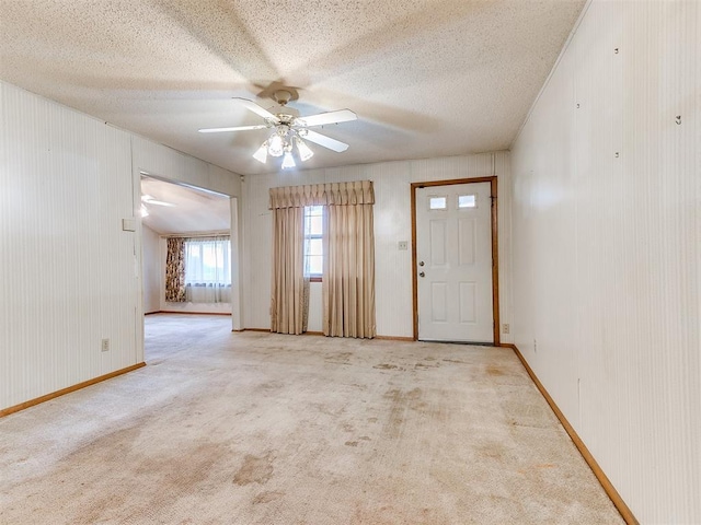 carpeted spare room with a textured ceiling and ceiling fan