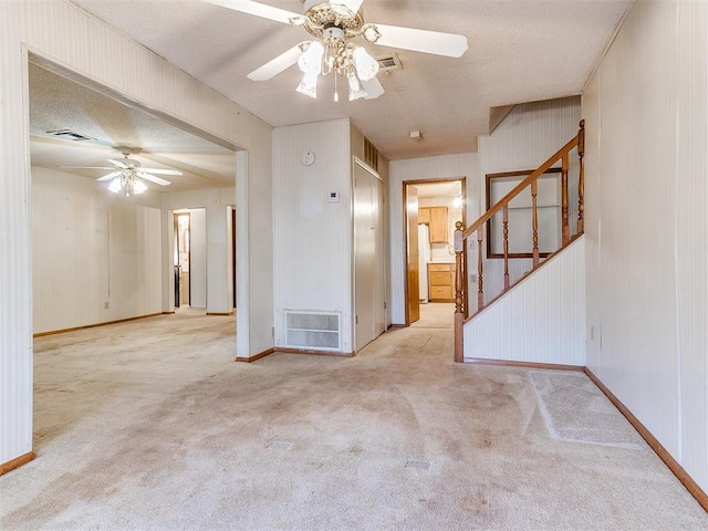 carpeted empty room with ceiling fan and a textured ceiling