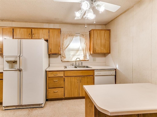 kitchen featuring a textured ceiling, white appliances, light colored carpet, ceiling fan, and sink