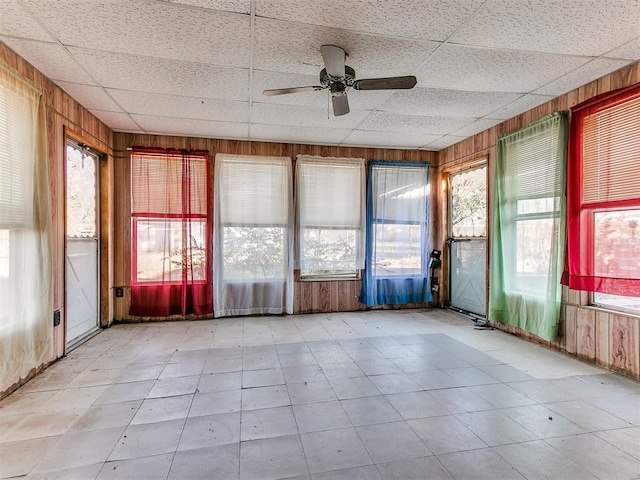 unfurnished sunroom with a drop ceiling and ceiling fan