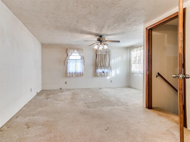 carpeted empty room with a textured ceiling and ceiling fan