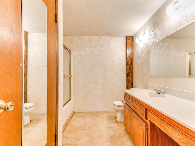 full bathroom featuring vanity, bath / shower combo with glass door, and toilet