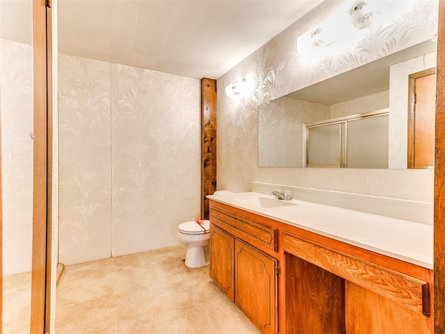 bathroom with vanity, a shower with shower door, and toilet