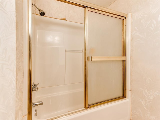 bathroom with bath / shower combo with glass door