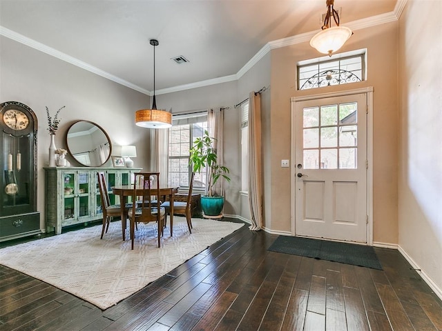 entrance foyer with dark hardwood / wood-style floors, a wealth of natural light, and ornamental molding