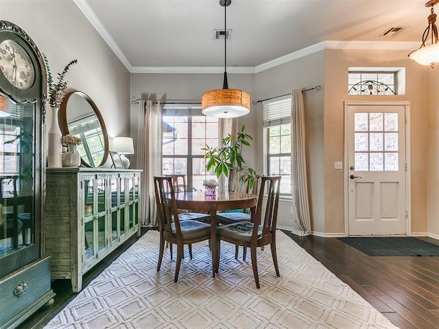 dining room featuring crown molding, plenty of natural light, and wood-type flooring