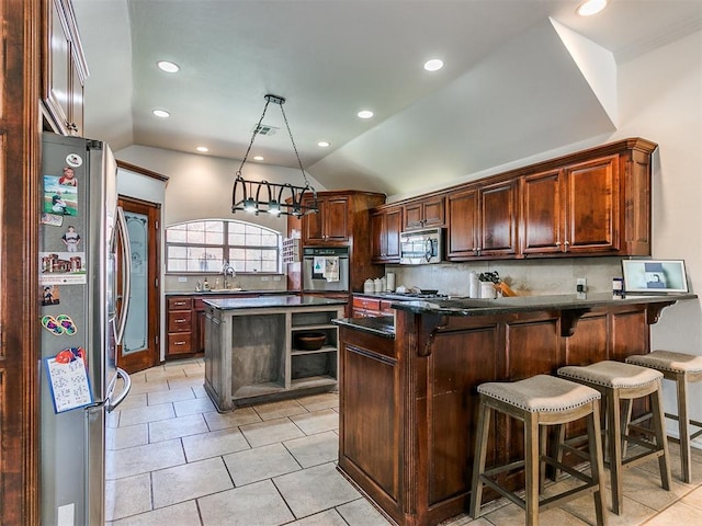 kitchen featuring appliances with stainless steel finishes, backsplash, a kitchen island, and lofted ceiling