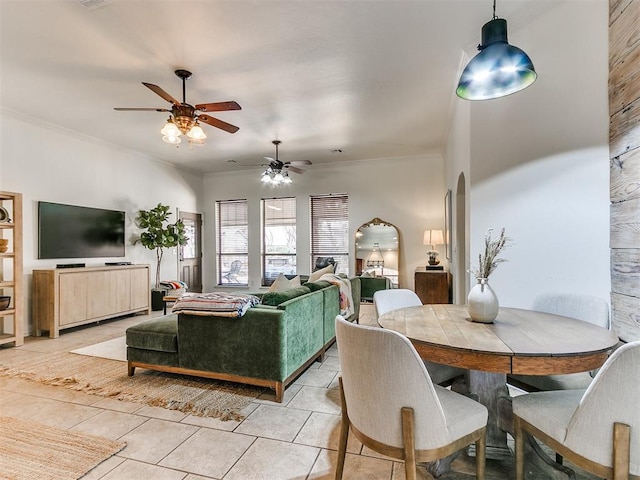 tiled dining area featuring ceiling fan and ornamental molding