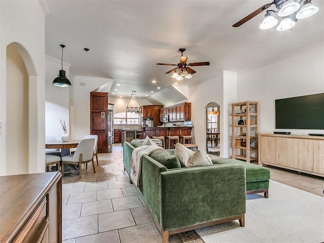 living room with ceiling fan, light tile patterned flooring, crown molding, and vaulted ceiling