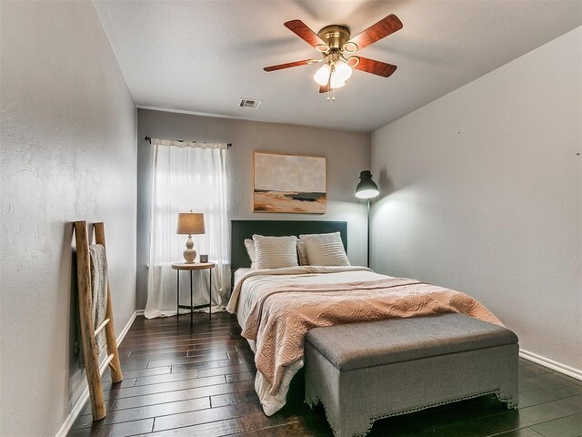 bedroom with dark hardwood / wood-style floors and ceiling fan