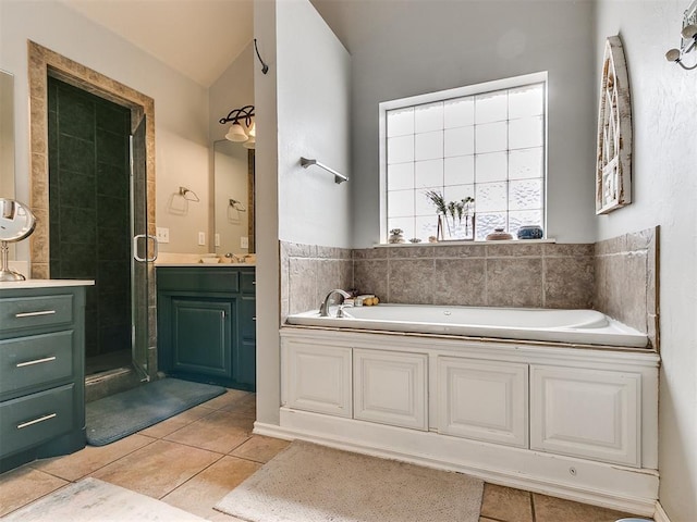 bathroom with plus walk in shower, vanity, tile patterned floors, and vaulted ceiling