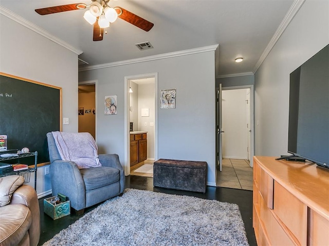 sitting room with ceiling fan, dark tile patterned floors, and ornamental molding