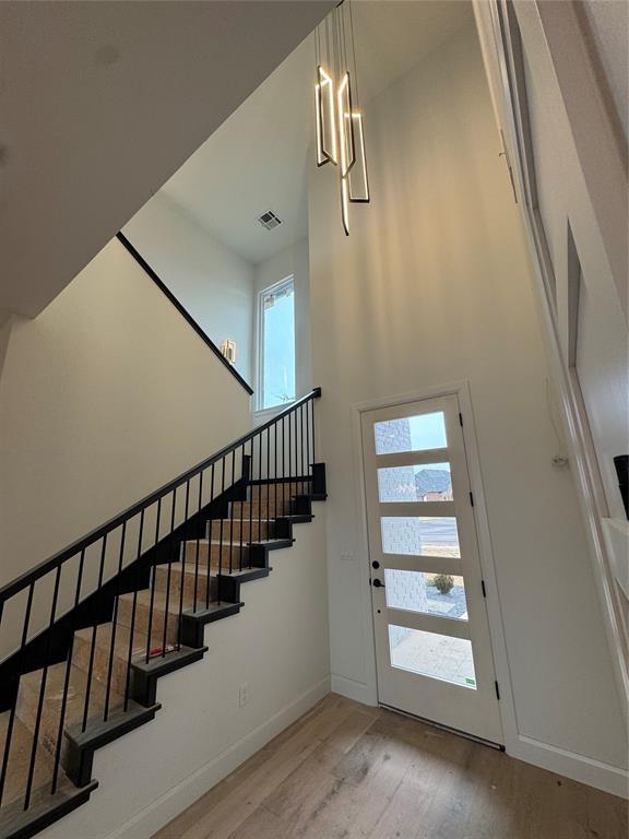 foyer featuring a towering ceiling and hardwood / wood-style floors