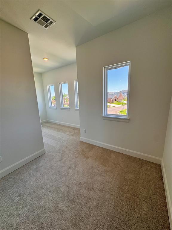 8409 NW 128th St, Oklahoma City, OK 73142 - spare room featuring light carpet and baseboards