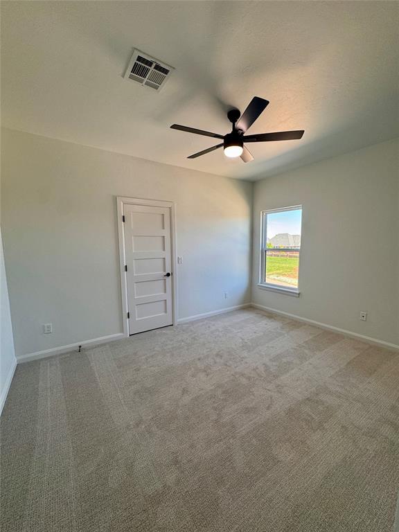 8409 NW 128th St, Oklahoma City, OK 73142 - unfurnished room with ceiling fan, baseboards, and light carpet