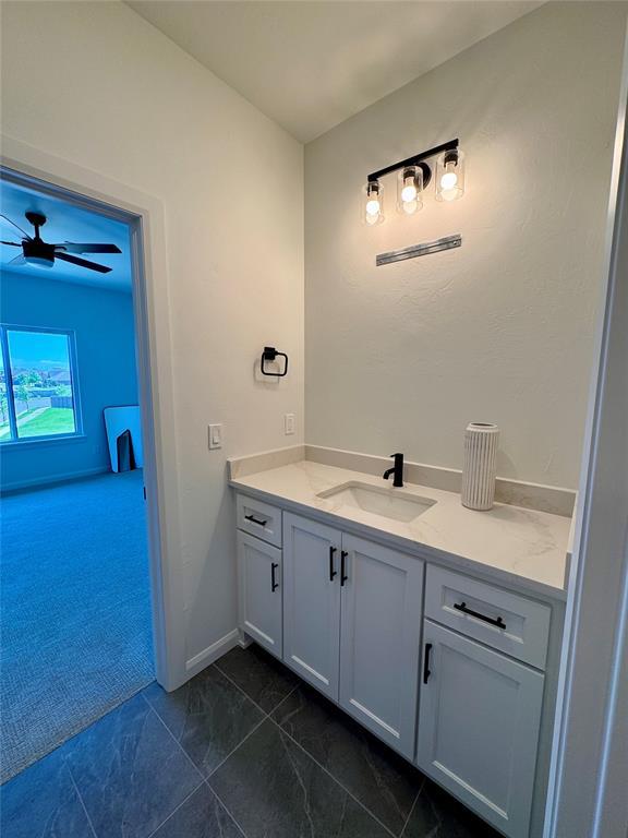 8409 NW 128th St, Oklahoma City, OK 73142 - bathroom featuring vanity, ceiling fan, baseboards, and marble look tile flooring