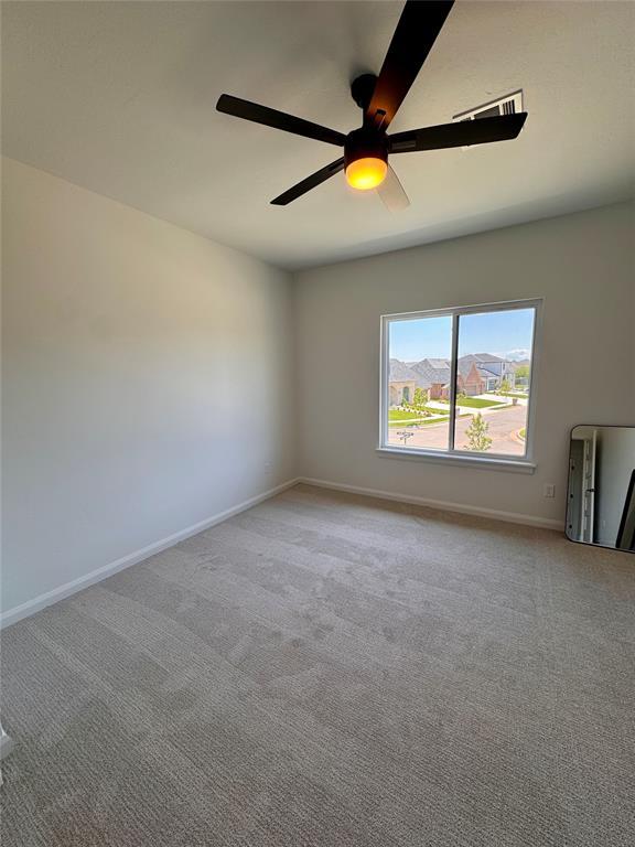 8409 NW 128th St, Oklahoma City, OK 73142 - spare room featuring carpet, baseboards, and ceiling fan