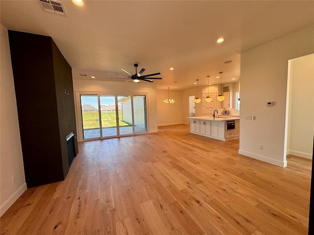 8409 NW 128th St, Oklahoma City, OK 73142 - unfurnished living room with a sink, baseboards, light wood-style floors, ceiling fan, and recessed lighting