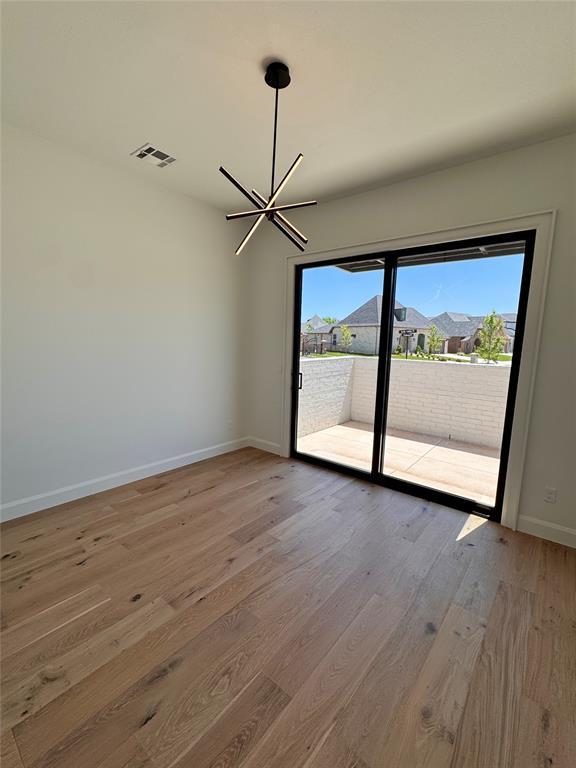 8409 NW 128th St, Oklahoma City, OK 73142 - unfurnished room featuring wood finished floors, a chandelier, and baseboards