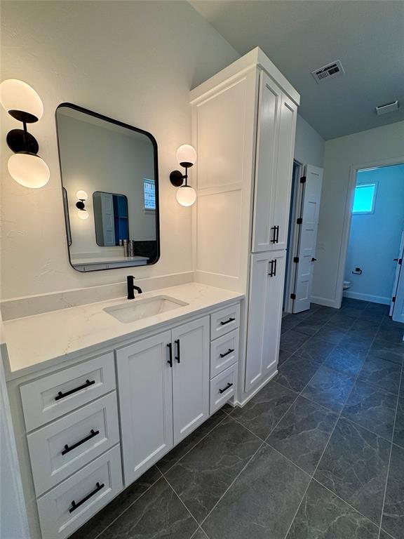 8409 NW 128th St, Oklahoma City, OK 73142 - bathroom featuring vanity and marble finish flooring