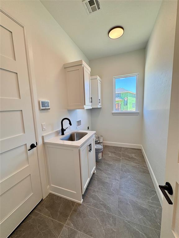 8409 NW 128th St, Oklahoma City, OK 73142 - laundry area featuring washer hookup, cabinet space, dark marble finish floors, and hookup for an electric dryer