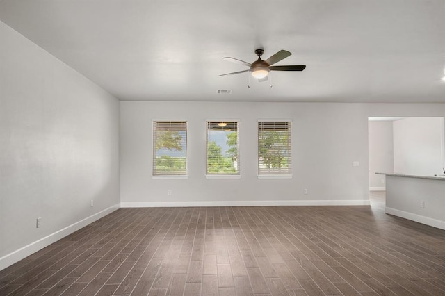 empty room with dark hardwood / wood-style floors and ceiling fan